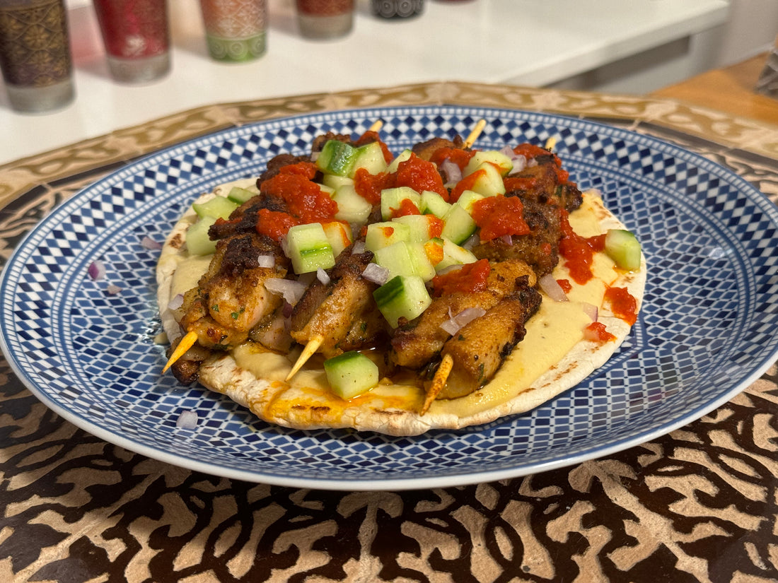 Chicken Skewers served on Pita bread, hummus and Mustaphas Harissa Hot Sauce